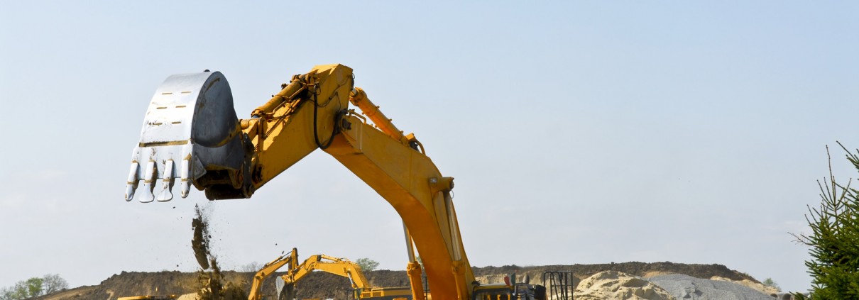 Yellow bulldozer machines digging and moving earth at construction site