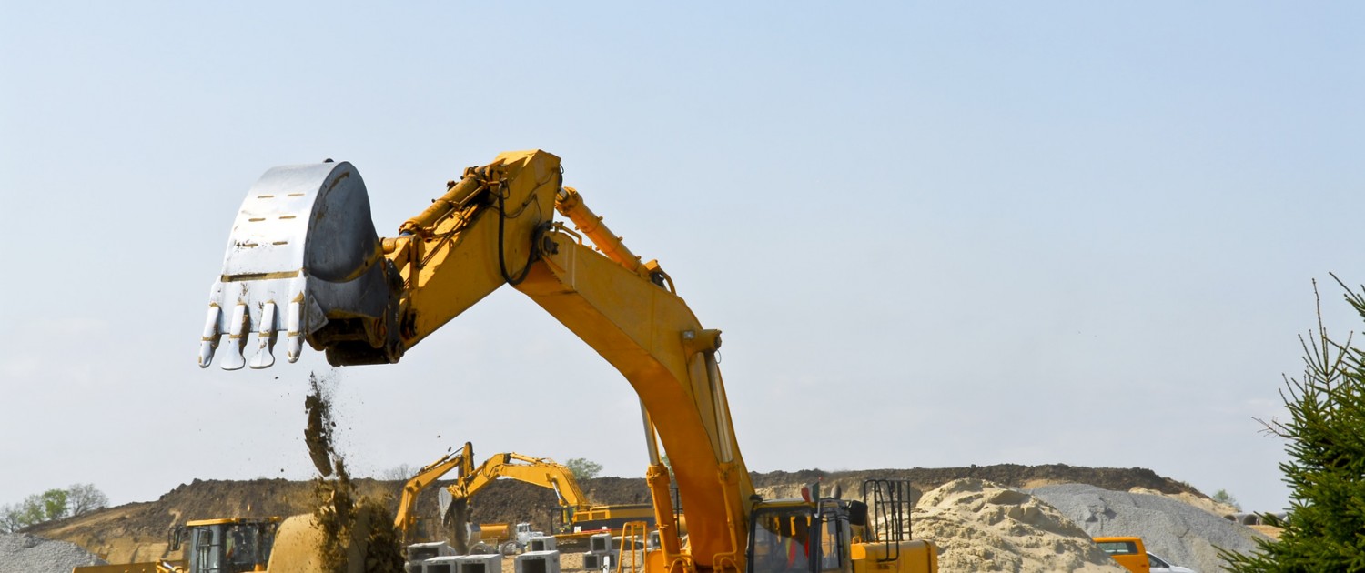 Yellow bulldozer machines digging and moving earth at construction site