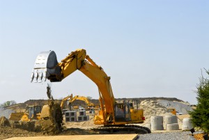 Yellow bulldozer machines digging and moving earth at construction site